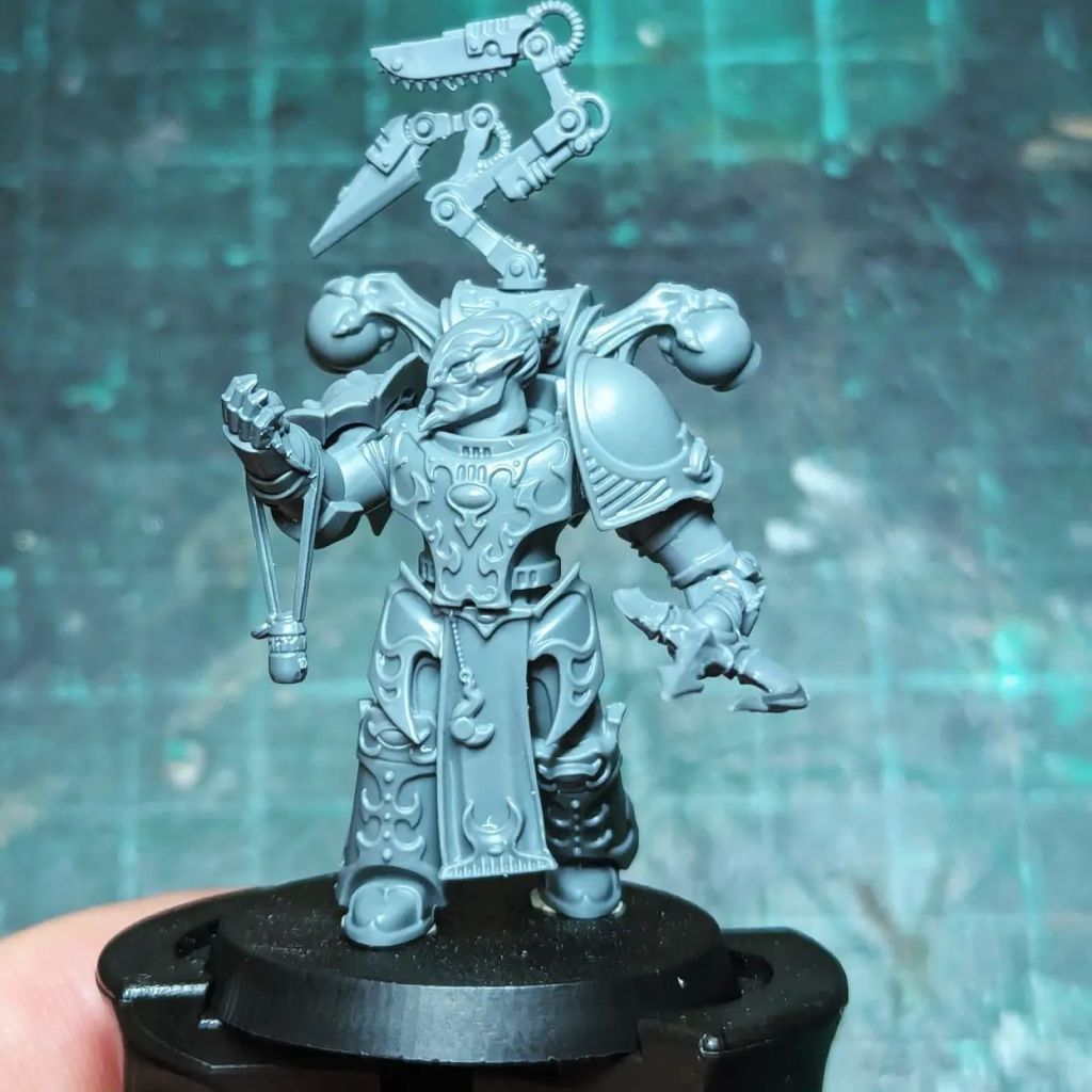 Chosen Chaos Space Marine Warhammer 40000 (40k) Tzeentch Apothecary Creations of Bile holding a Tzeentcian axe from the Age of Sigmar Varanguard and inspecting extracted Geneseed